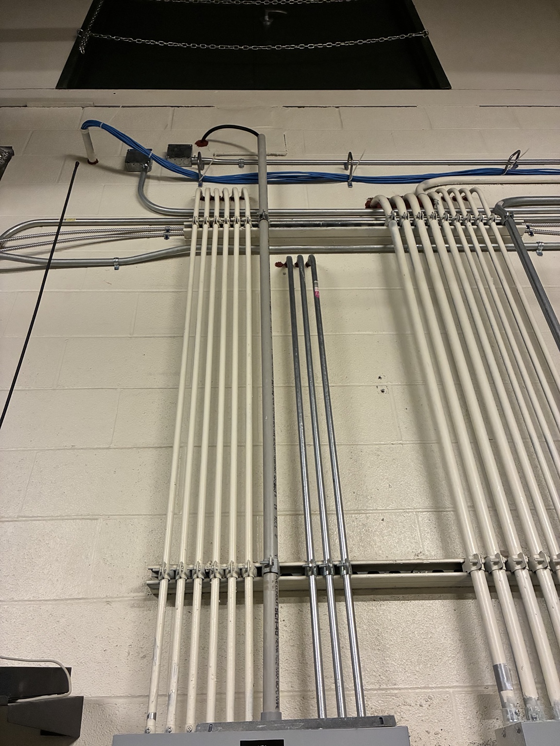 Commercial electrical panel installation with conduit entering above the enclosure