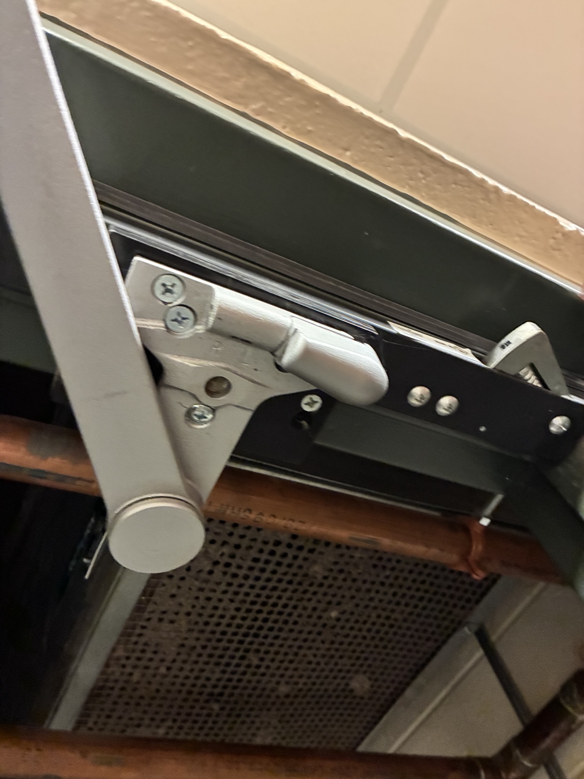 Close view of a commercial door closer arm and frame bracket