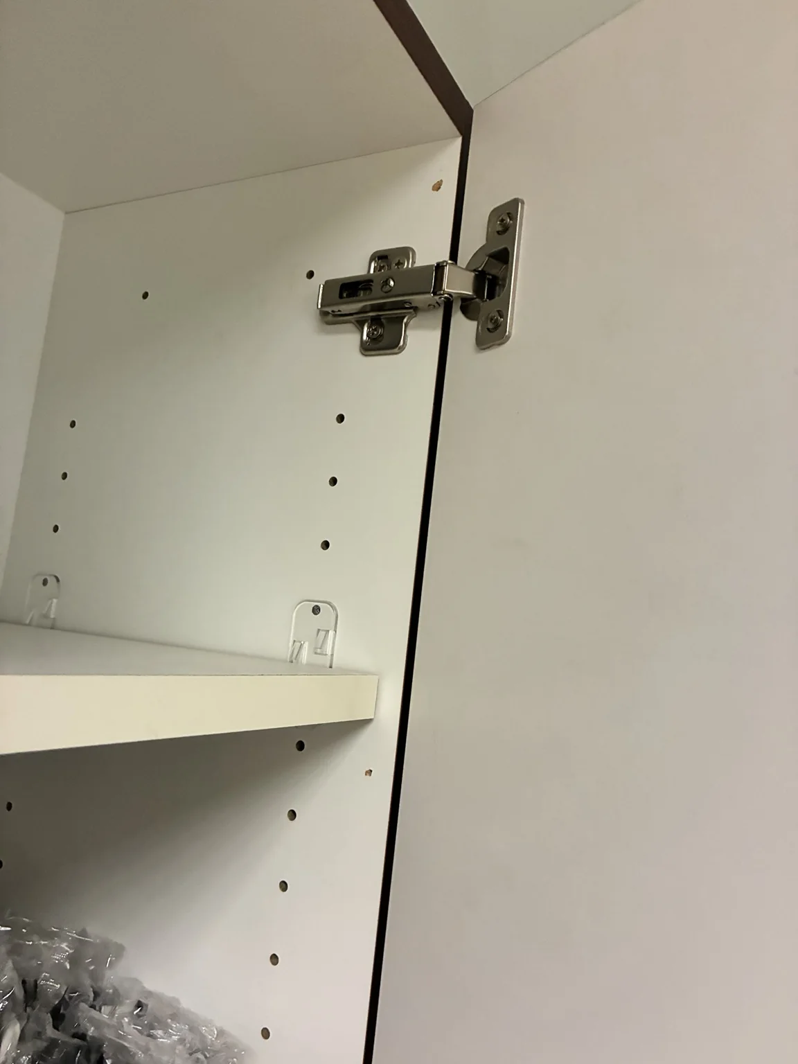 Bisagra del gabinete y espacio de la puerta que muestra la alineación